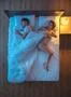 The woman pull a duvet on the bed. evening night time. view from above Photo