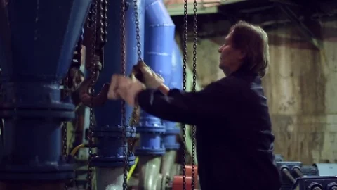 Woman pulled the chain and move hoist Stock Footage 70717287