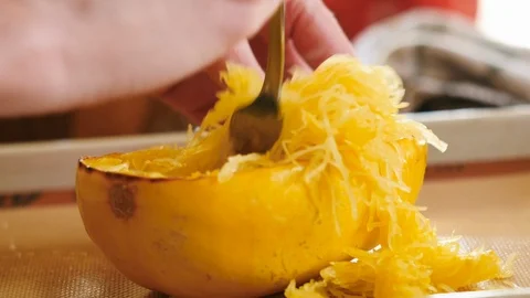 Woman Pulling Apart Spaghetti Squash with a Fork Stock Footage 125124658