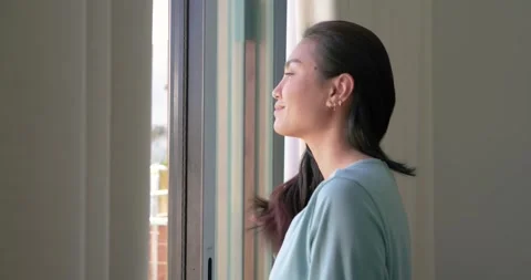 Woman pulling curtains aside and sliding glass door open in bedroom to inhale Stock Footage 337624268