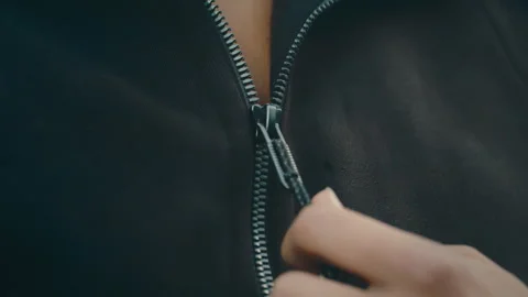 Woman pulling down jacket zipper in extreme slow motion, close up 4k Video stock 273660022