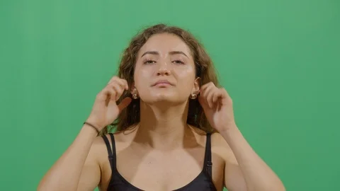 Woman pulling his ears studio isolated shot against green screen background Stock Footage 117712976
