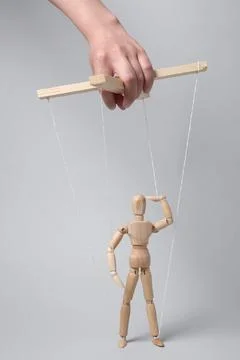 Woman pulling strings of puppet on light grey background, closeup 스톡 사진