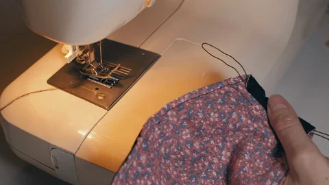 Woman pulling thread through home made face mask, during coronavirus pandemic. Stock Footage 127277820