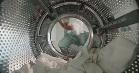 A woman pulls clean washed white linen from the washing machine Stock Footage 136549822