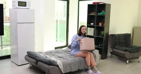 Woman pulls down cardboard box filled with clothes in room Stock Footage 310214571