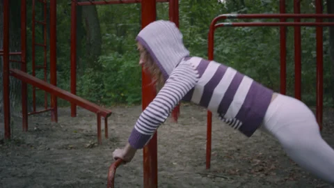 A woman pulls herself up on a horizontal bar. 스톡 동영상 139085752