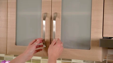 Woman pulls mug out of the kitchen cupboard and closes the cabinet door Stock Footage 121763557