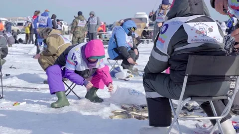 The woman pulls out the caught fish and puts it on the ice Stock Footage 185238187