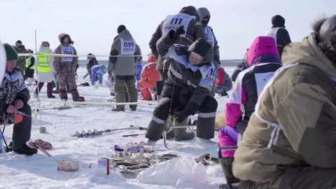 The woman pulls out the caught fish and puts it on the ice Stock Footage 188600787