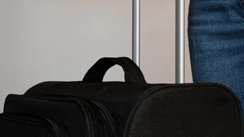 A woman pulls out a telescopic handle in a black travel bag. Stock Footage 306936106
