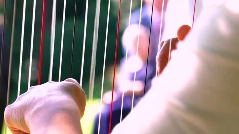 Woman Pulls the Strings to Play Harp Outdoor, Close Up, Slow Motion Video stock 161129296