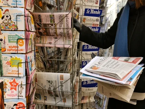 Woman purchases stack of German Dutch French Turk newspaper with The Trump Show Stock Footage 71701088