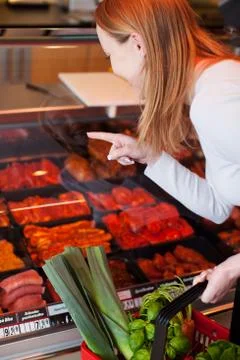 Woman purchasing meat at a delicatessen Stock Photos