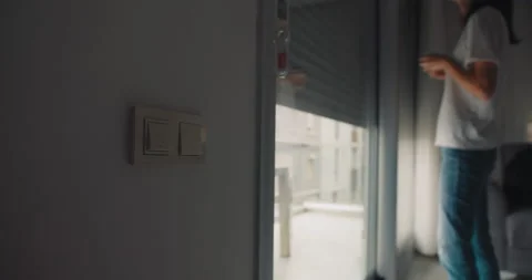 Woman push switch button of automatic roller shutter open the window Stock Footage 228563271
