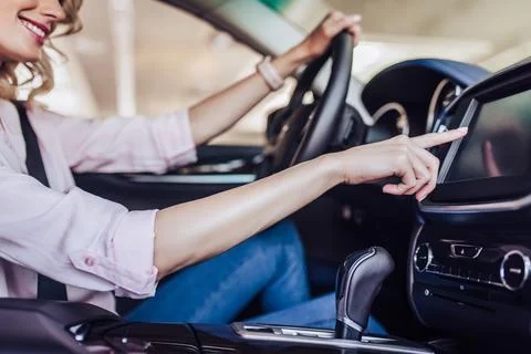 Woman pushing button on the dashboard in the car Stock Photos