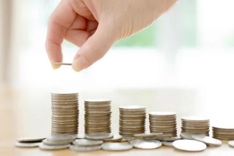 Woman put coins to stack of coins Stock Photos