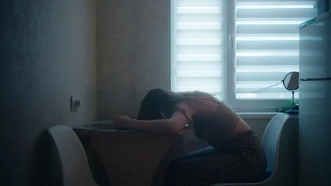 Woman put her head on the table and knocks on it with her fist in the kitchen Stockbeeldmateriaal 249669161