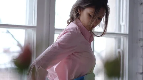 Woman puts on an apron. View through flowers. Vídeo Stock 86178957