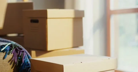 Woman puts a box on boxes, moving to a new house, packing things Stock Footage 164209881