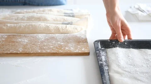 Woman puts the bread in baking sheet. Bread. 4K Stock Footage 121527475