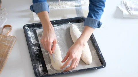 Woman puts the bread in baking sheet. Bread. 4K Video stock 121527517