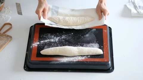 Woman puts the bread in baking sheet. Bread. 4K Stock Footage 121527596