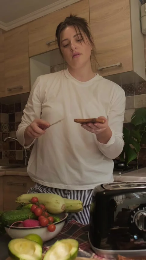 Woman puts bread into toaster preparing healthy breakfast with avocado and Stock Footage 311865877