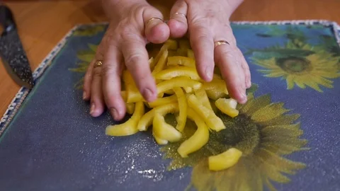 The woman puts the chopped pepper in a Cup of salad. Preparation of vegetables Stock Footage 123724798