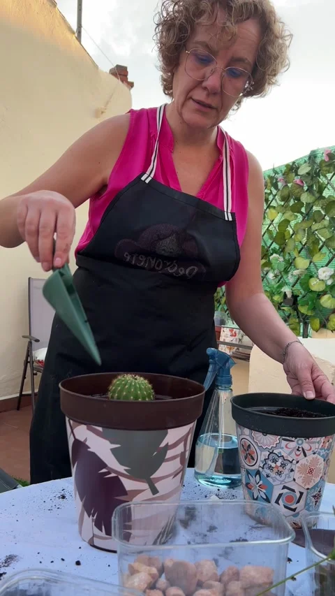 A woman, puts compost in a pot using a gardening trowel. Home gardening concept Stock Footage 209150290