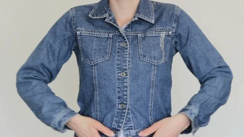 A woman puts on a denim jacket Stock Footage 129624201