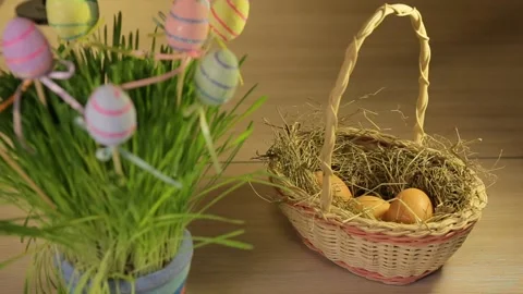 A woman puts Easter eggs in a basket with hay. Only hands. Easter decorations Stock Footage 106059333