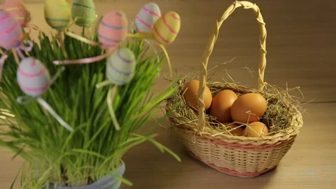 A woman puts Easter eggs in a basket with hay. Only hands. Easter decorations Stock Footage 106059370