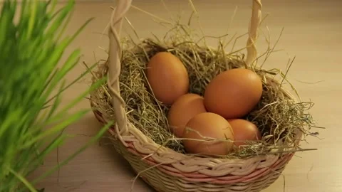 A woman puts Easter eggs in a basket with hay. Only hands. Easter decorations Stock Footage 106059411