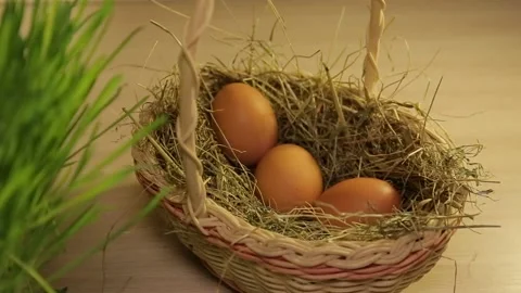 A woman puts Easter eggs in a basket with hay. Only hands. Easter decorations Stock Footage 106064813