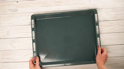 Woman puts an empty baking tray on the table owerhead view Stock-Footage 197441197