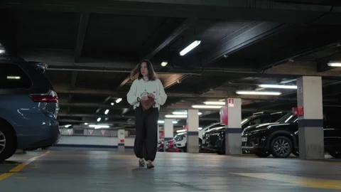 Woman Puts Keys in Bag While Walking Through Underground Parking Garage Stock Footage 336733190