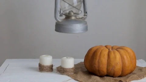 Woman puts a lantern on a table next to a pumpkin and candles. Stock Footage 113758330