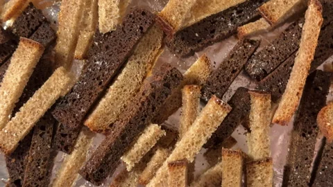 A woman puts pieces of rye bread on a baking tray to make breadcrumbs 스톡 동영상 301247589