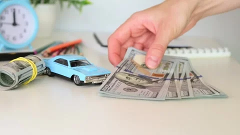 A woman puts a stack of money on a table near a miniature typewriter 動画素材 247188930