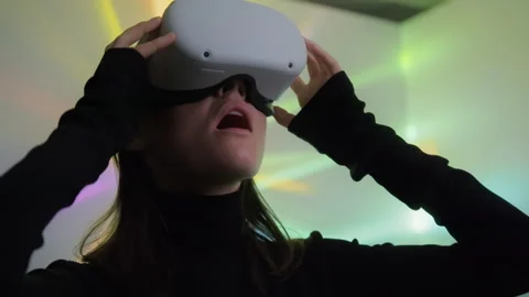 Woman puts on virtual reality headset and admires beauty of digital 3D space Stock Footage 242507170