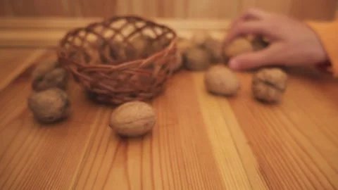 Woman puts walnuts in shells in wicker basket. Stock Footage 194424283