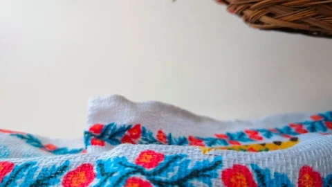 Woman puts a wicker plate with Easter eggs, white background Stock Footage 105926220