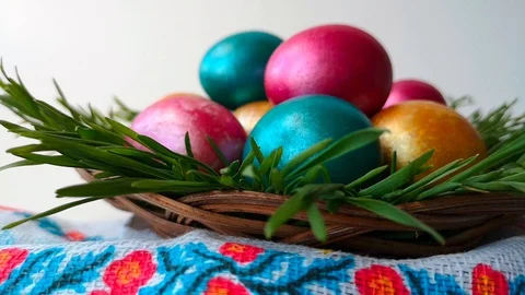 Woman puts a wicker plate with Easter eggs, white background Stock Footage 105926225