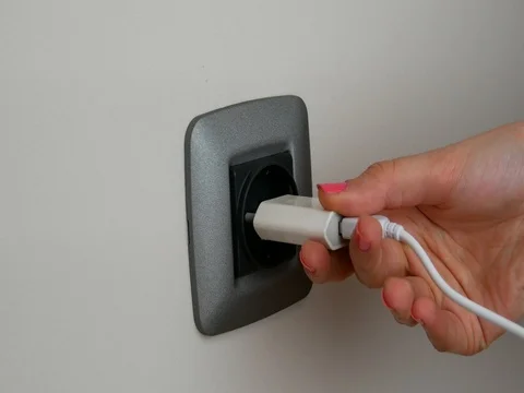Woman putting plug  into a wall socket Stock Footage 72274153