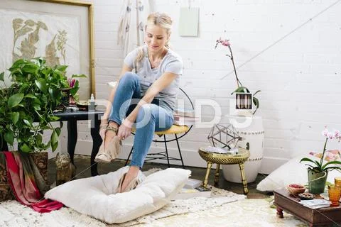 A woman putting on suede boots. Stock Photos