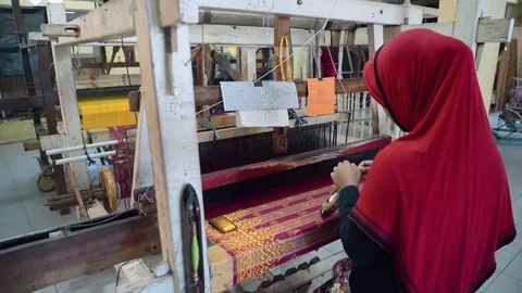 Woman putting thread to shuttle for weaving fabric with foot-treadle loom Stock Footage 79144164