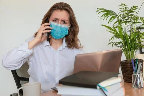 Woman in quarantine for Coronavirus wearing protective mask and smart working Stock Photos