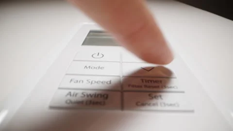 The woman quickly presses the temperature decrease button on the air conditioner 库存影片 246441500