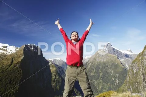 Woman Raising Arms Against Mountain Peaks Stock Photos
